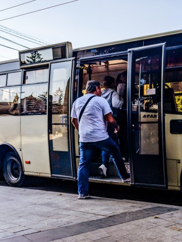 люди заходять в автобус