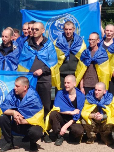 чоловіки з синьо-жовтими прапорами на плечах