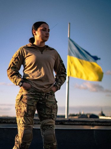 жінка на фоні прапора.