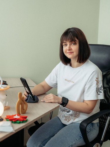 Жінка за комп'ютером з 3D-світильниками на столі.