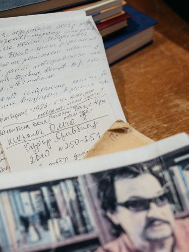 Рукописний текст та фото на письмовому столі.