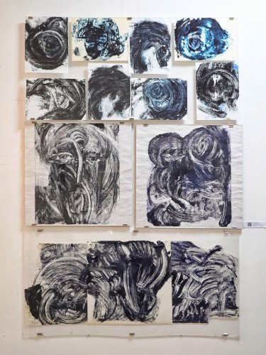 13 чорно-білих монотипів темної фарби на білому аркуші, що нагадують хмари, очі та лик Христа.