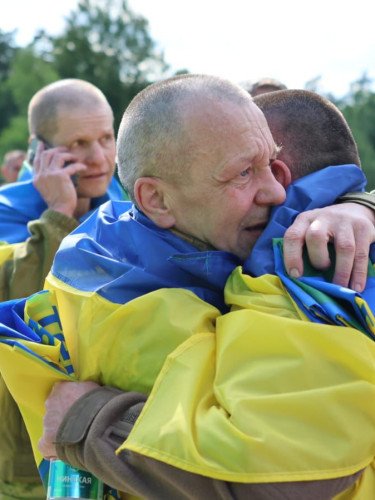 військові з жовто-блакитними прапорами на плечах