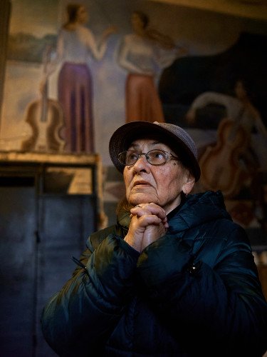 Жінка стоїть у холі колишнього парадного входу до луцького музучилища, згодом Луцької тюрми