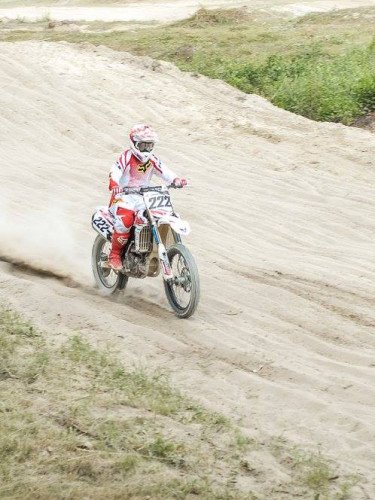 мотоцикліст їде по грунтовій дорозі