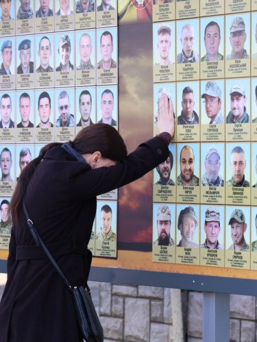 жінка біля фотостенду