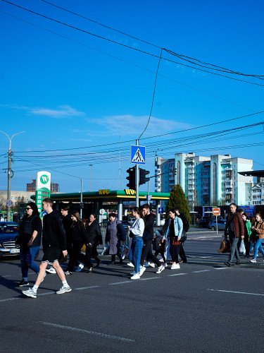 Люди йдуть через пішохідний перехід.