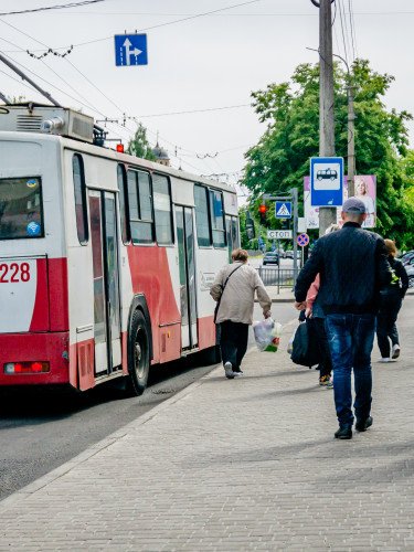 Зупинка, люди йдуть до тролейбусу.