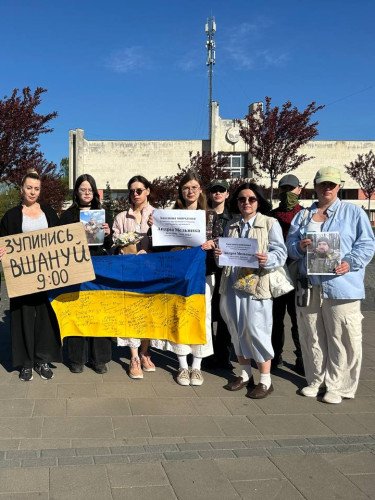 люди з плакатами на хвилині мовчання