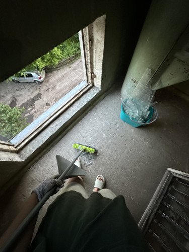 Людина підмітає розбите скло.