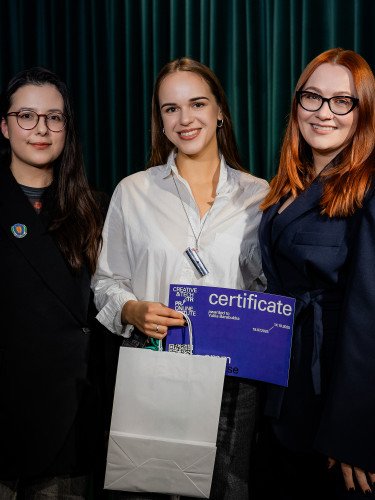 Троє жінок, в однієї з них - сертифікат в руках.