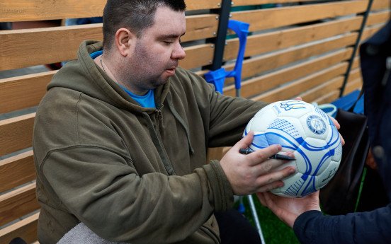 Гравці підписують м’яч. Павло Сокаленко на першому фото.