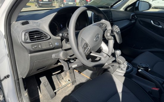 Вигляд авто всередині. На кермі встановлено спеціальний пульт, а на педалях — додатковий механізм.
