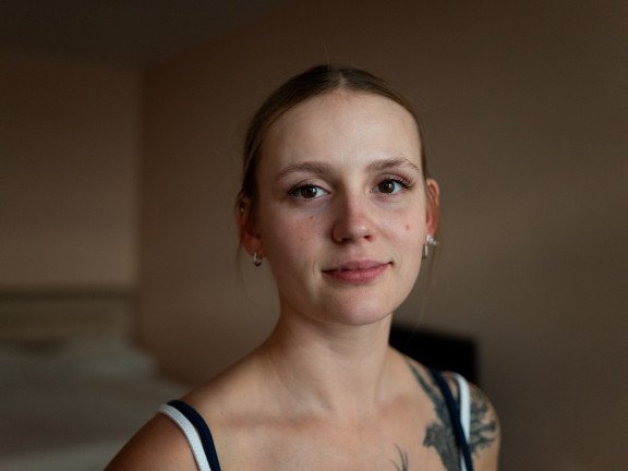 Юна дівчина з татуюванням птаха на плечі.