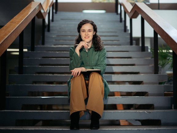 кучерява жінка сидить на сходах