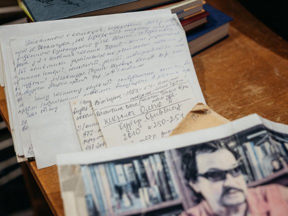 Рукописний текст та фото на письмовому столі.