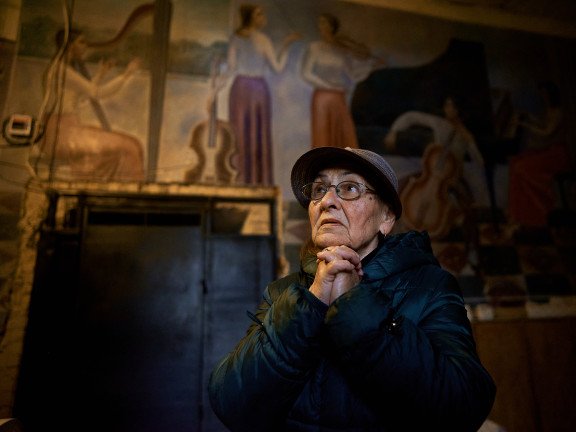 Жінка стоїть у холі колишнього парадного входу до луцького музучилища, згодом Луцької тюрми