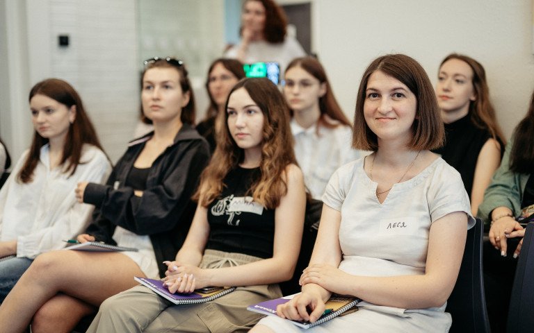 жінки сидять у залі та щось уважно слухають