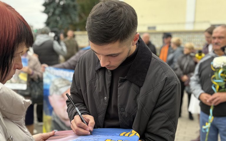 Чоловік підписує прапор