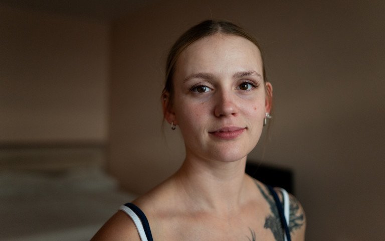Юна дівчина з татуюванням птаха на плечі.