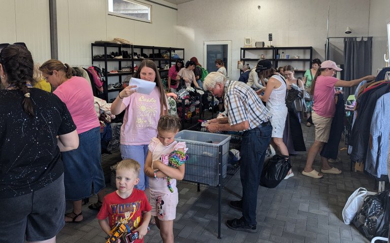 Люди різного віку беруть з полиць речі.