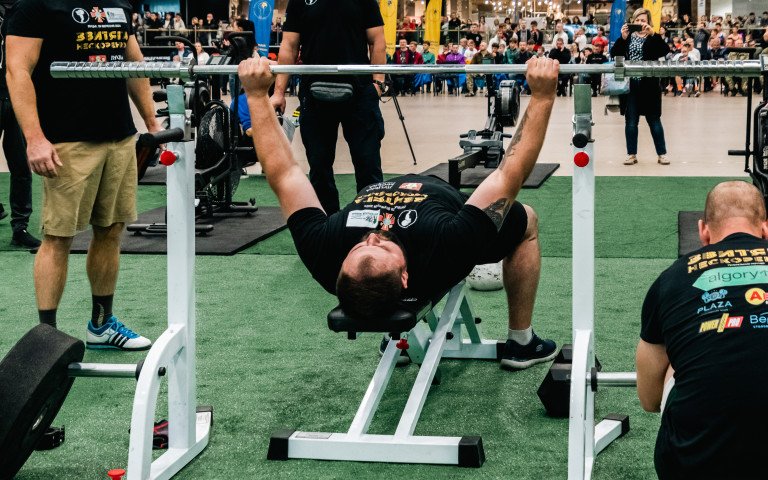 спортсмен піднімає штангу