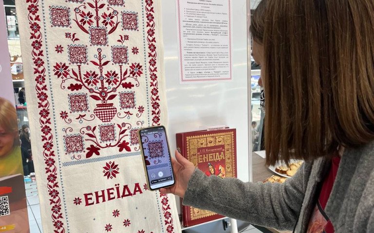 жінка сканує QR-код.