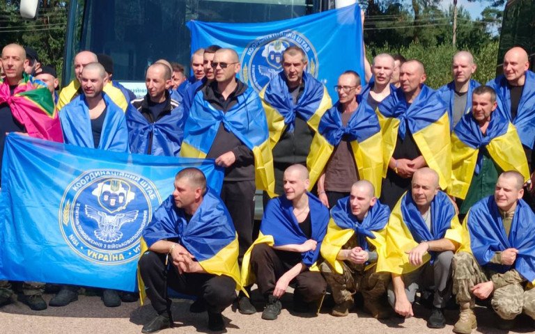 чоловіки з синьо-жовтими прапорами на плечах