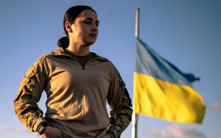 жінка на фоні прапора.