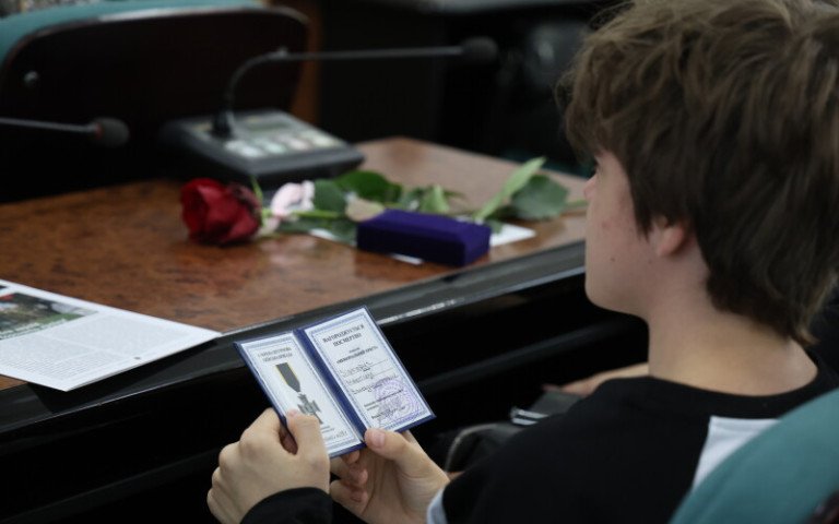 вручення посмертних нагород військовим у Луцьку хлопець тримає нагородну книжечку