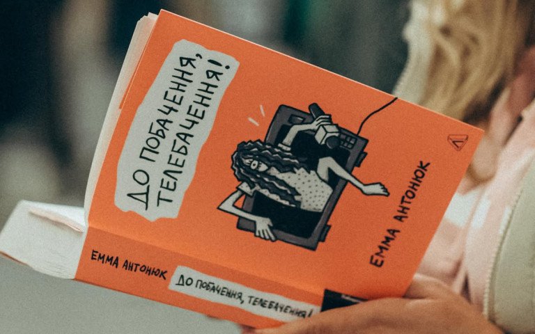 людина тримає книгу в руках