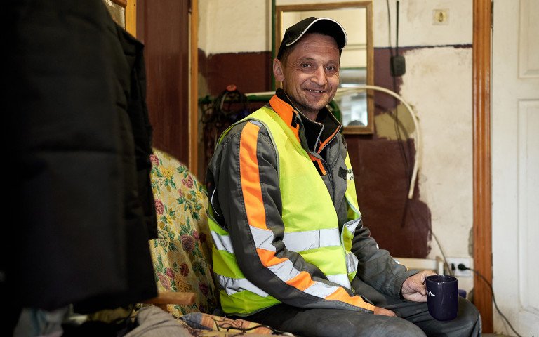 Віталій Сивий - старший сортувальник центру управління відходами. Чоловік у спецодязі та кепці сидить у невеликій сторожовій комірчині.