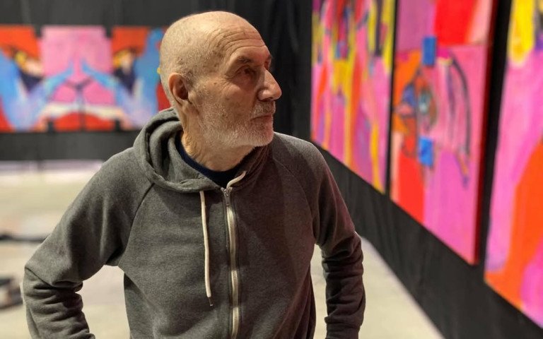 художник на фоні картин