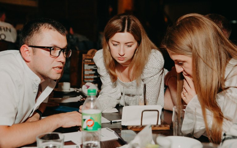 Троє людей обговорюють питання вікторини.