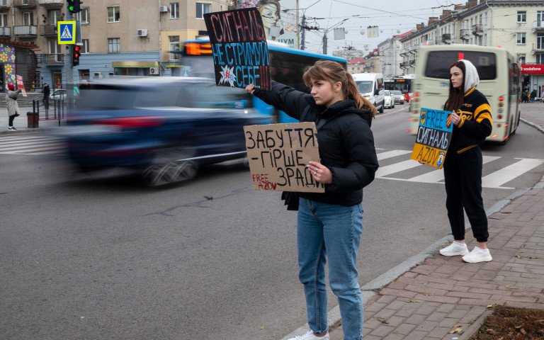 Дівчина тримає табличку з написом "Забуття гірше зради".