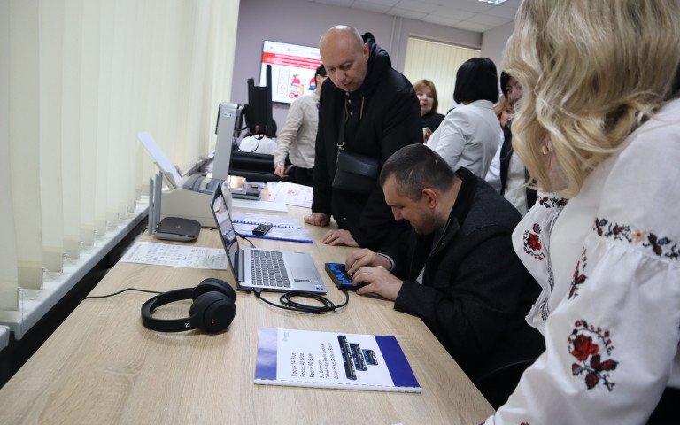 ноутбук з портативним дисплеєм Брайля Чоловік сидить за ноутбуком з портативним дисплеєм Брайля