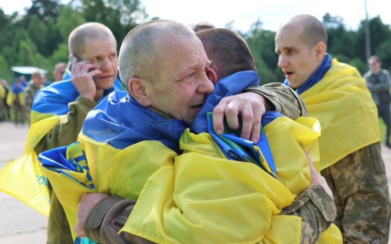 військові з жовто-блакитними прапорами на плечах
