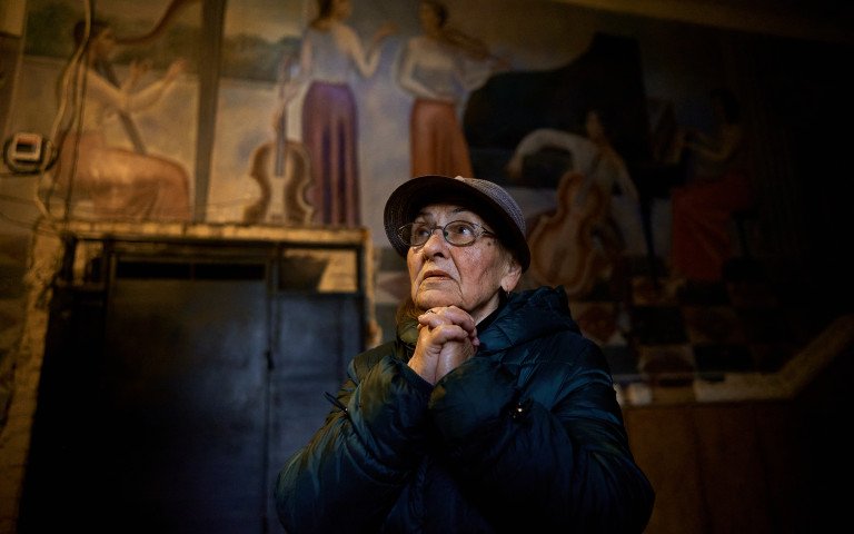 Жінка стоїть у холі колишнього парадного входу до луцького музучилища, згодом Луцької тюрми