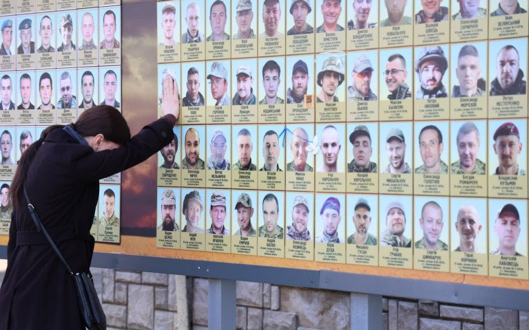 жінка біля фотостенду