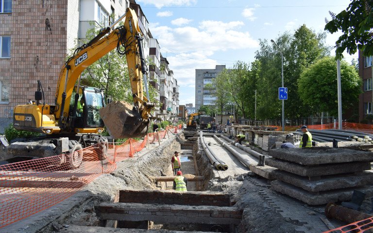 Ремонт тепломереж, багатоповерхівки, зелені дерева, комунальники у салатових жилетках, спецтехніка