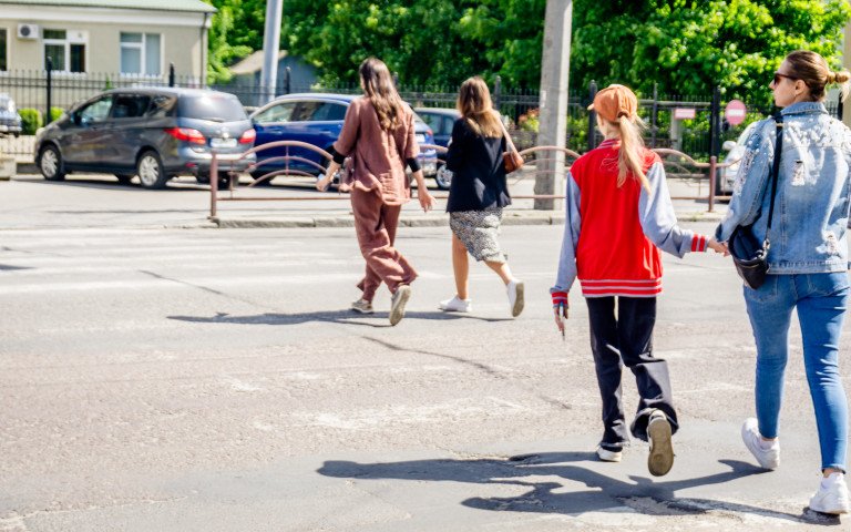 люди йдуть через пішохідний перехід