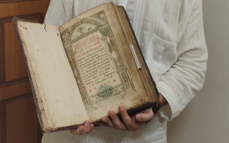 людина тримає книгу в руках