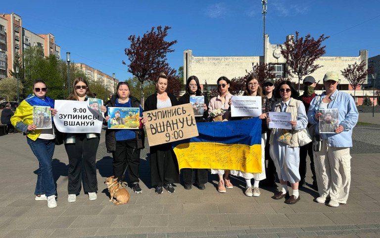 люди з плакатами на хвилині мовчання