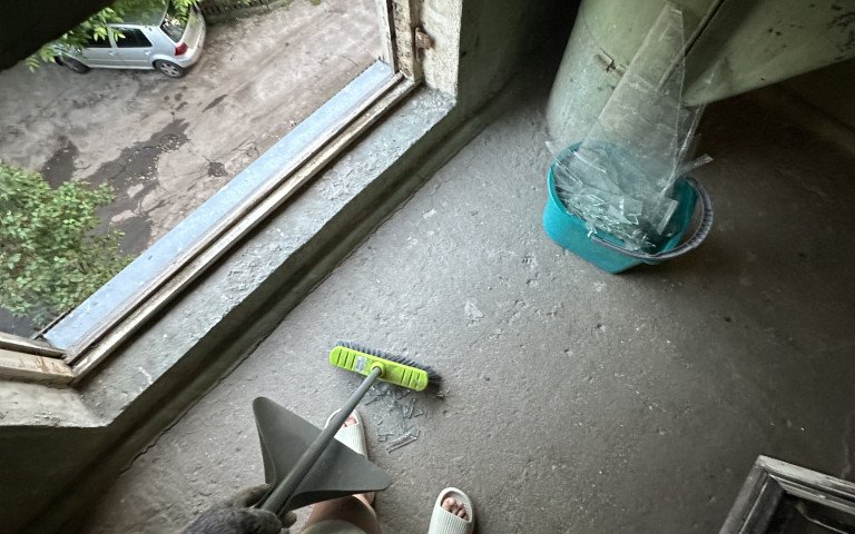 Людина підмітає розбите скло.