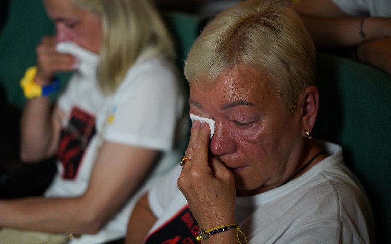 дві жінки, які плачуть та витирають обличчя від сліз