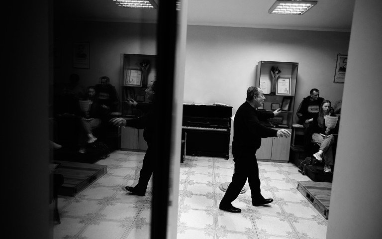 Василь Мойсіюк репетирує з «Орантою» новий репертуар. Чоловік у чорному одязі диригує хором.