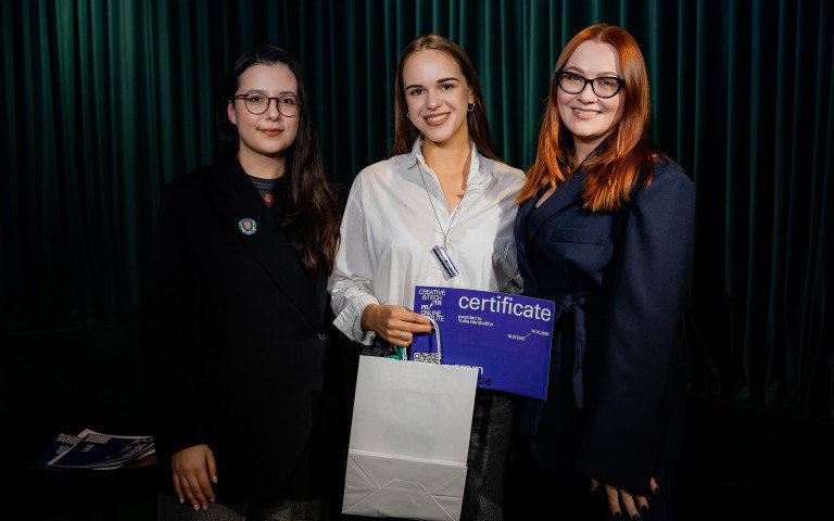 Троє жінок, в однієї з них - сертифікат в руках.