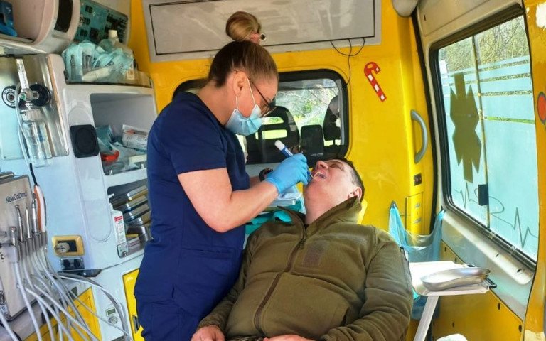 стоматолог лікує зуби військовому