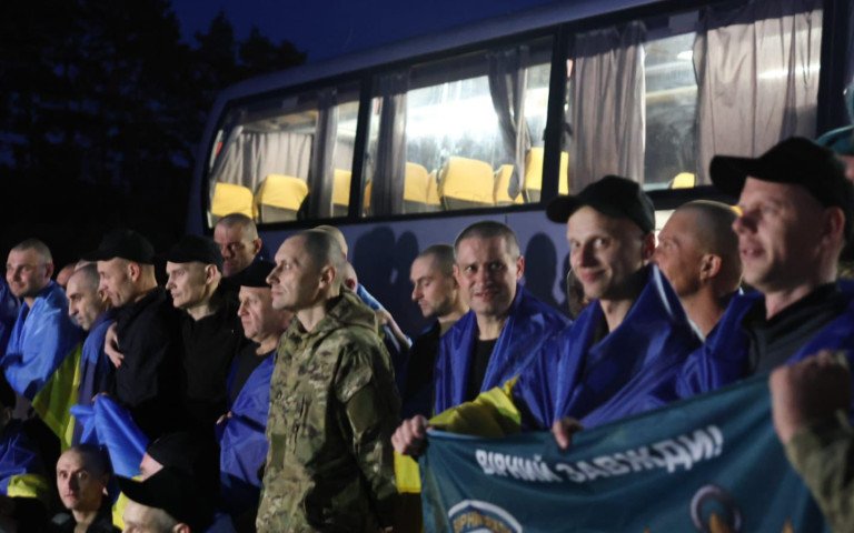 люди з прапорами на плечах