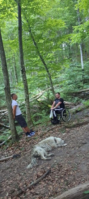 Волонтер перепочиває після того, як підняв на гору ветерана на візку